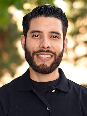 A person with short hair and beard smiling.