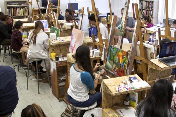 Image of students in a painting studio with easels, shot from above