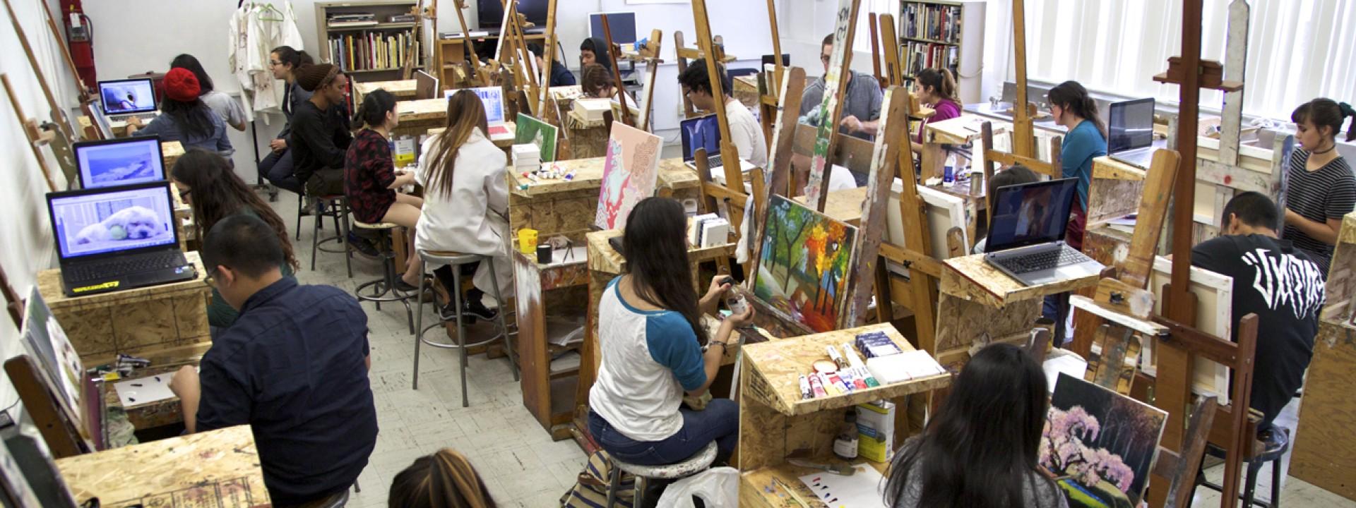 Image of students in a painting studio with easels, shot from above